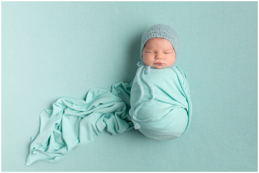 Lynne harper photography image of baby girl wrapped wearing aqua bonnet