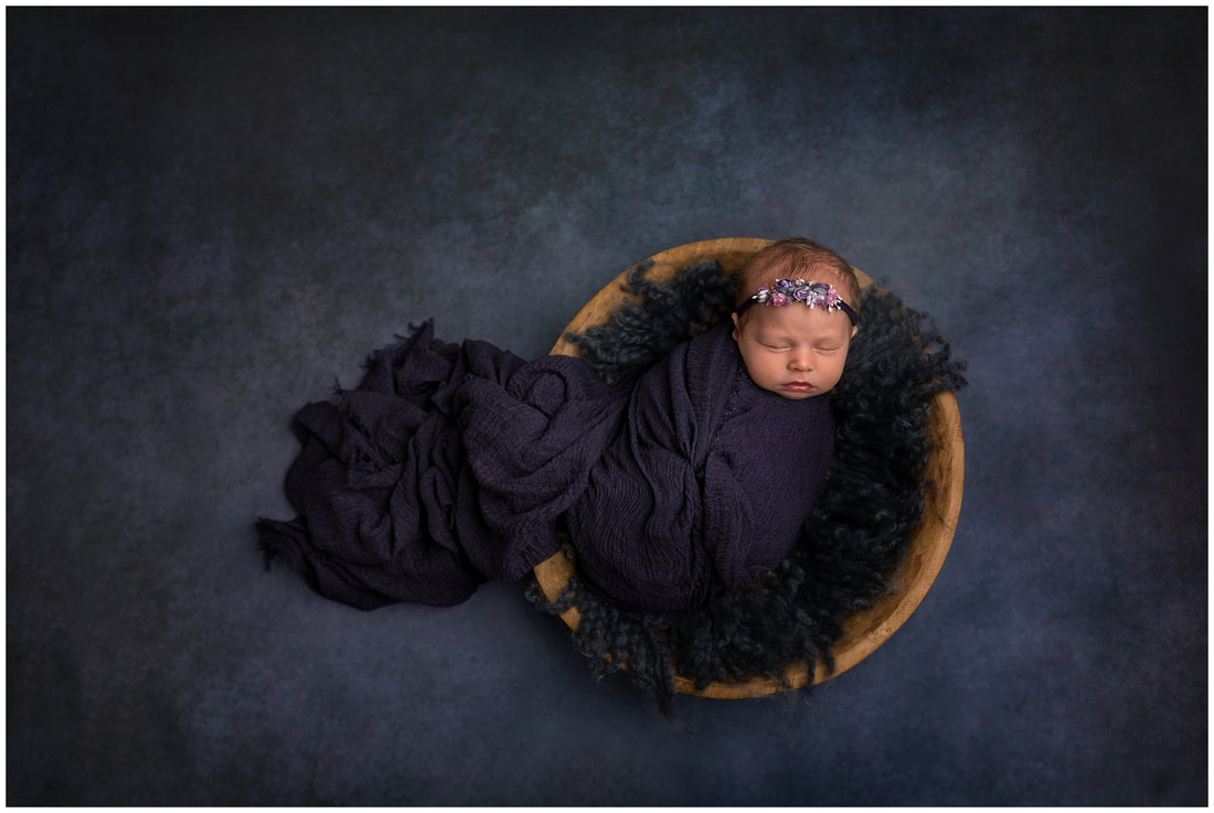 Deep blue wrapped newborn image of baby girl by Lynne Harper
