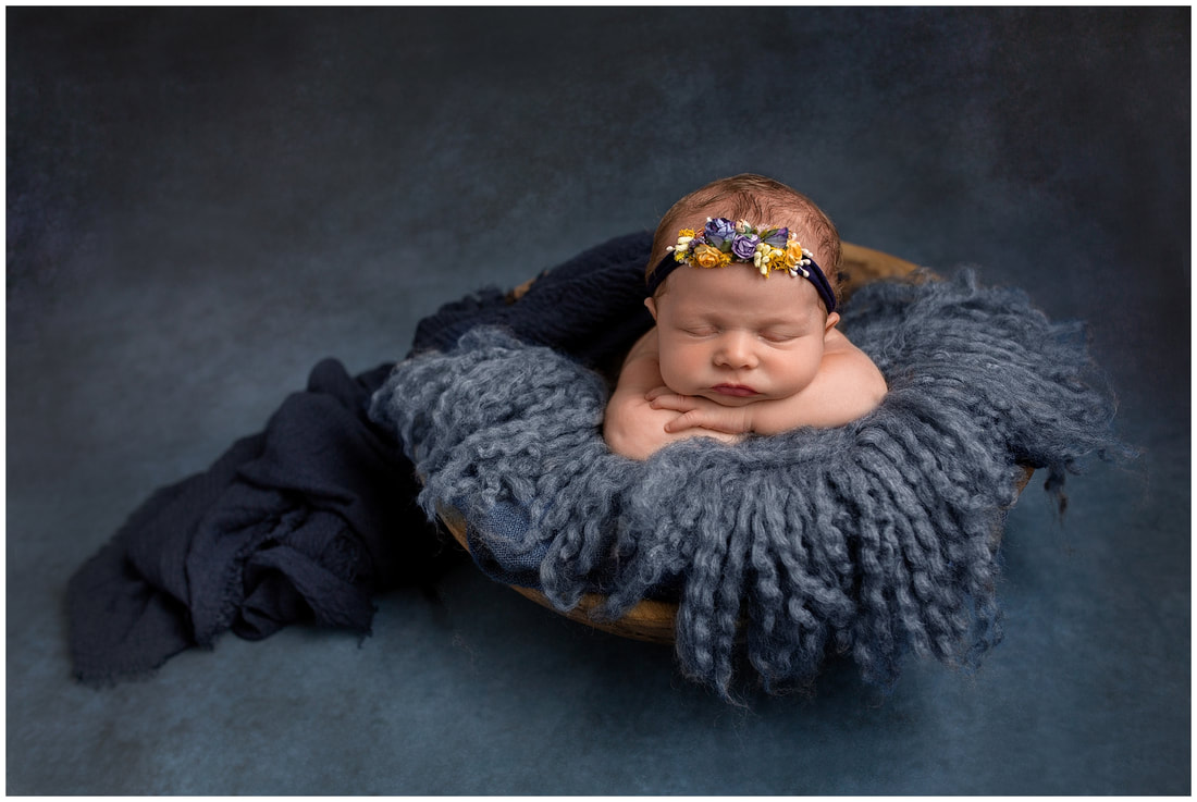 Front pose of newborn baby girl in blue by Lynne Harper
